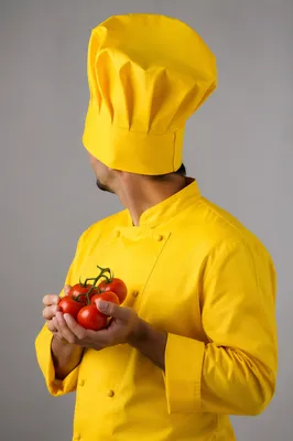 Chef Holding Fresh Tomatoes in Yellow Uniform
