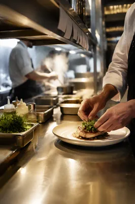Chef Plating Dish in Busy Restaurant Kitchen