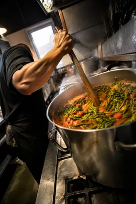 Chef Stirring Simmering Sauce in Restaurant Kitchen