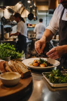 Chef Plating Meal in Busy Restaurant Kitchen