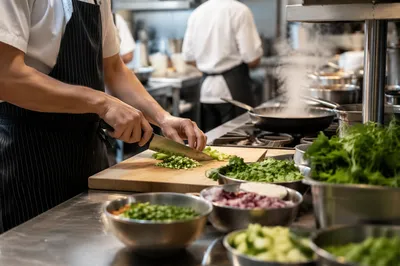 Busy Chef Preparing Vegetables in Restaurant Kitchen