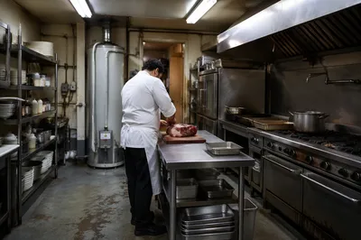 Chef Preparing Meat in Commercial Kitchen