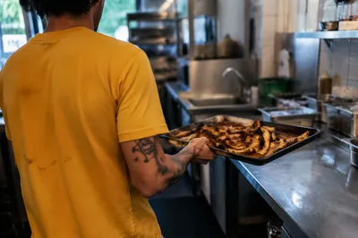 Busy Restaurant Kitchen Worker Cooking Tray