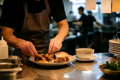 Chef Plating Dinner in Busy Restaurant Kitchen