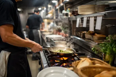Chef Sautéing Vegetables in Busy Restaurant Kitchen