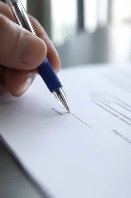 Signing Contract Document with Pen Close-Up