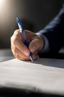 Hand Signing Business Contract with Blue Pen