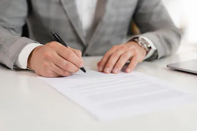 Businessperson Signing Contract on Office Desk
