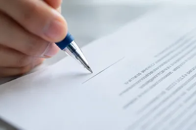 Hand Signing Contract with Blue Pen