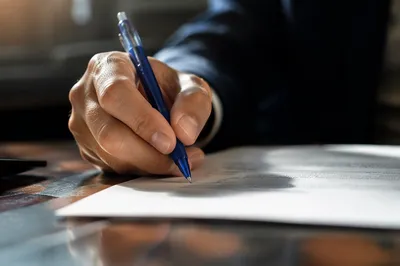 Hand Signing Business Contract with Blue Pen