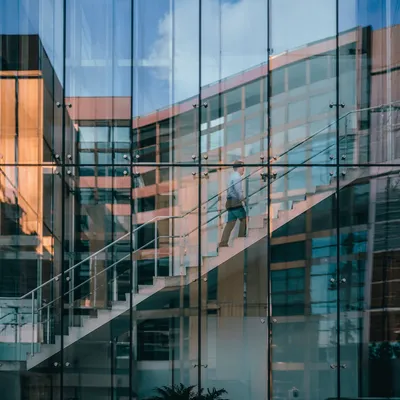 Ascending Office Staircase Through Reflective Glass