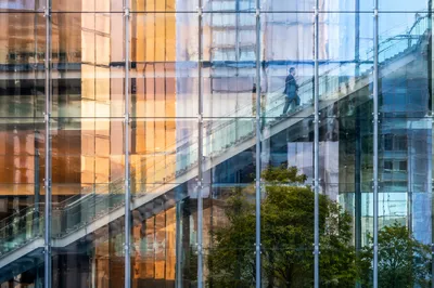 Ascending Office Staircase Through Reflective Glass