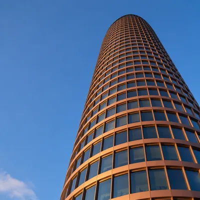 Modern Copper Office Tower Against Blue Sky