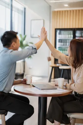 Coworkers Celebrating Project Success in Office Café