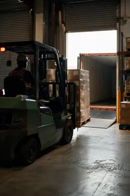 Warehouse Forklift Moving Pallet to Freight Container
