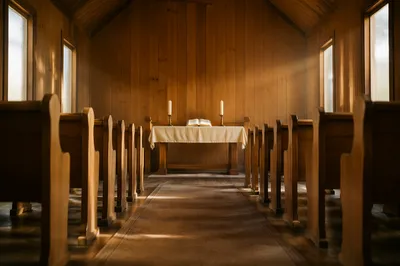 Sunlit Chapel Aisle Toward Simple Altar