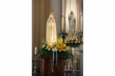 Church Altar Flowers and Candlelit Devotional Statue