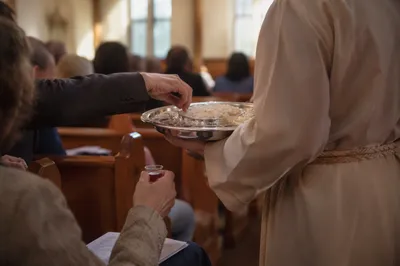 Deacon Serving Communion in Church Aisle
