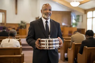 Deacon Carrying Communion Trays in Church