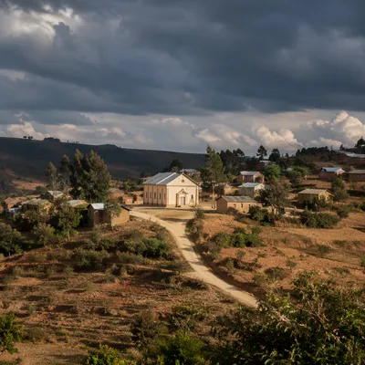 Rural Village Church Under Storm Clouds