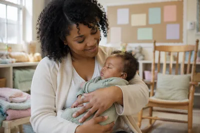 Volunteer Holding Baby in Bright Nursery