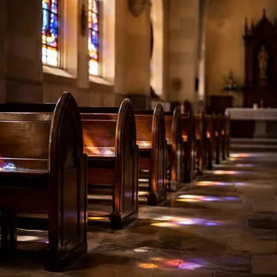 Sunlit Church Pews Beneath Stained Glass