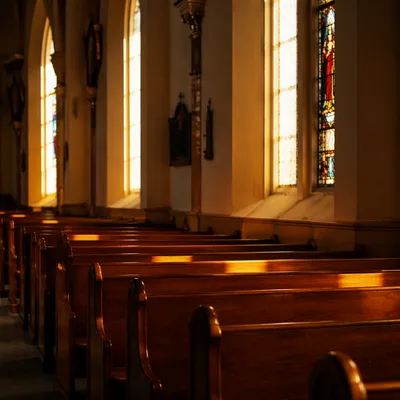 Sunlit Church Pews by Stained Glass