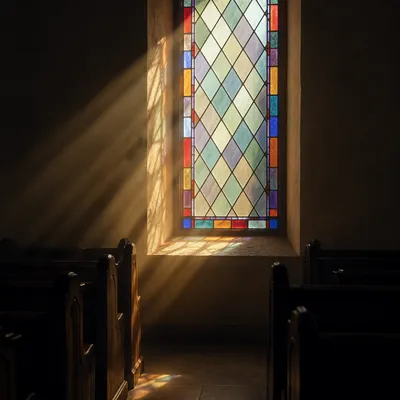 Sunlit Chapel Pews and Stained Glass
