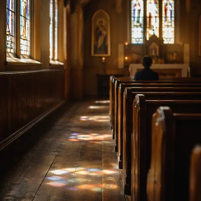 Sunlit Chapel Pews with Stained Glass