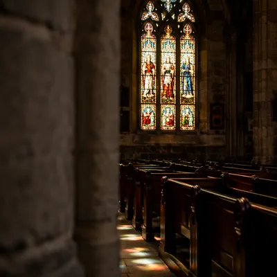 Sunlit Stained Glass Over Quiet Church Pews