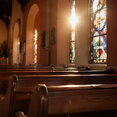 Sunlit Church Pews With Stained Glass