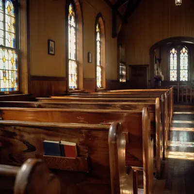 Sunlit Chapel Pews with Stained Glass
