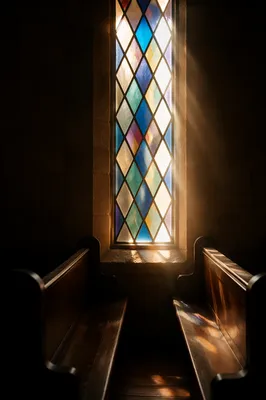 Sunlit Chapel Pews and Stained Glass