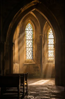 Sunlit Church Pews Beneath Stained Glass