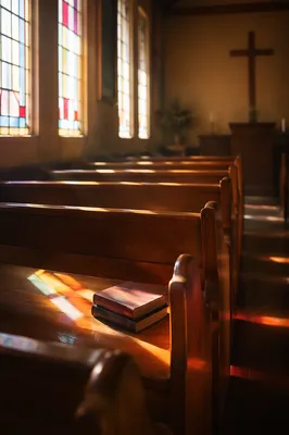 Sunlit Chapel Pews with Stained Glass