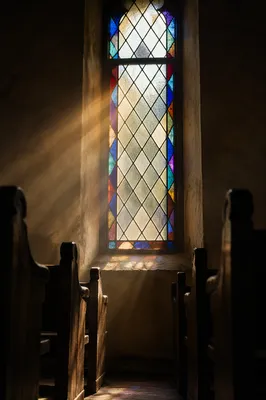 Sunlit Chapel Pews and Stained Glass