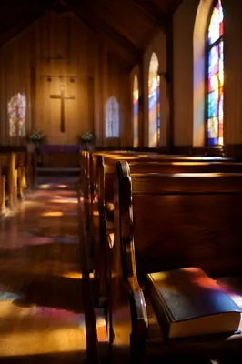 Sunlit Chapel Pews with Stained Glass