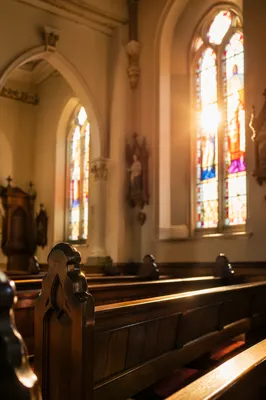 Sunlit Church Pews with Stained Glass