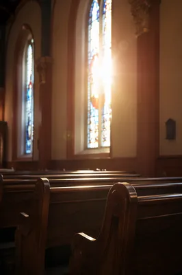 Sunlit Church Pews with Stained Glass
