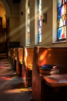 Sunlit Church Pews With Stained Glass