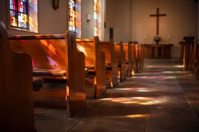 Sunlit Church Pews with Stained Glass