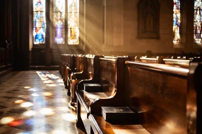 Sunlit Church Pews with Stained Glass
