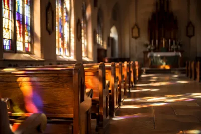 Sunlit Church Pews and Stained Glass