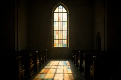 Sunlit Church Pews Beneath Stained Glass