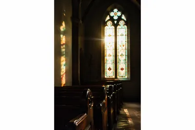 Sunlit Church Pews and Stained Glass