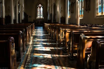 Sunlit Church Pews and Stained Glass