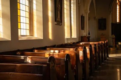 Sunlit Church Pews by Stained Glass