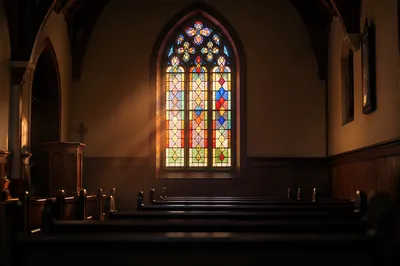 Sunlit Stained Glass Above Church Pews
