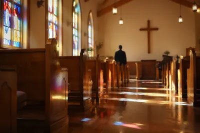 Sunlit Chapel Pews With Stained Glass