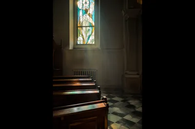 Sunlit Church Pews with Stained Glass